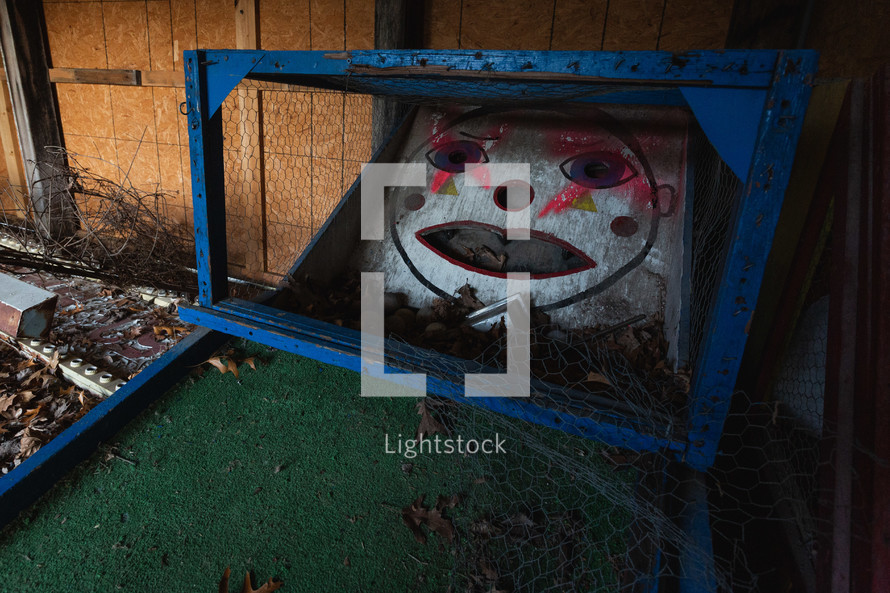 Old, mini golf game with graffiti on face