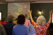 women with raised hands at a worship service 