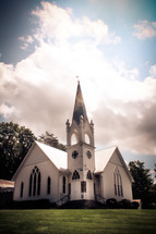 a white church with white clouds
