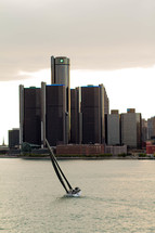 sailboat on the water with a city view 