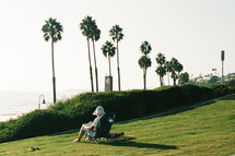 person reading in a park by a beach 