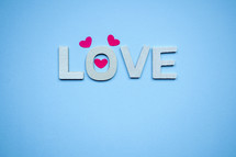 love wooden letters and heart shape on the blue background, feelings and emotions