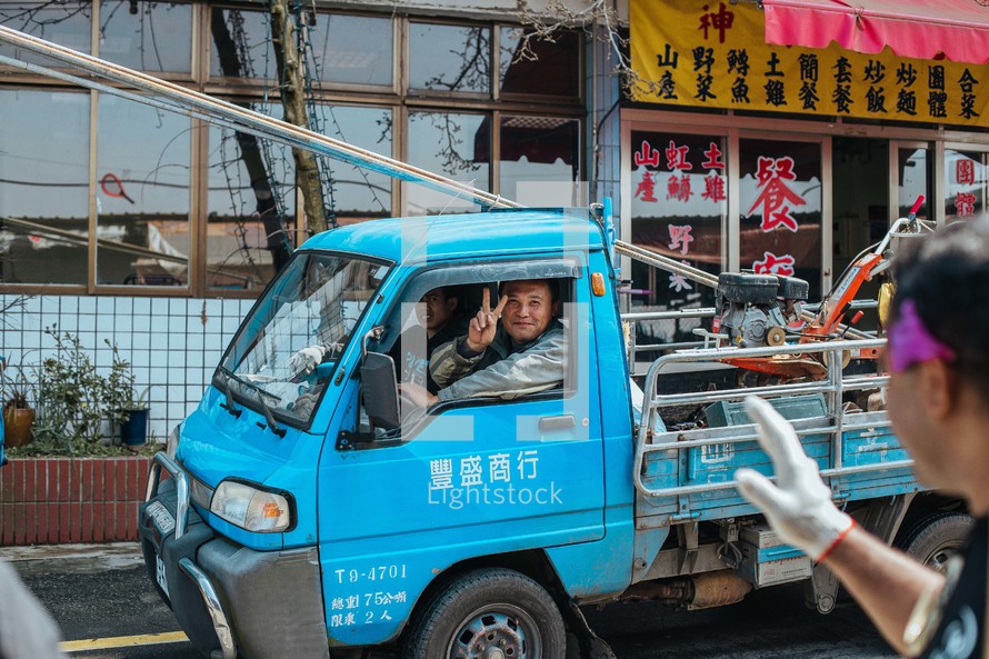 man in a small truck in Taiwan giving a peace sign 