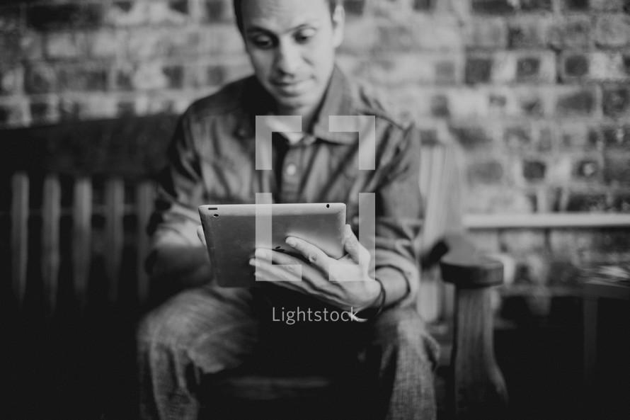 Latino man looking at an iPad screen 