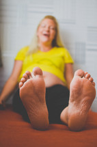 a pregnant mother looking at her swollen feet 