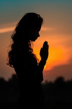 Silhouette of a woman praying