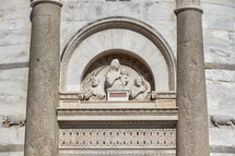 engravings above a church door in Pisa