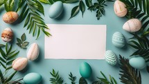 Easter greeting card mockup with pastel easter eggs, green leaves and copy space on blue background