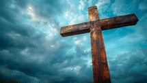 Wooden cross on a background of blue sky with white clouds.