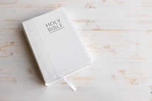 white Bible on a white wood background 