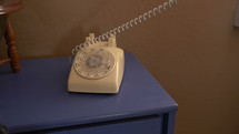 A woman slamming down a vintage telephone in frustration