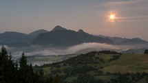 Moon set dawn at sunrise in foggy mountains landscape Time lapse
