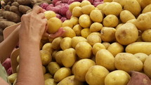 A woman buying potatoes at the grocery store