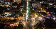 aerial nighttime photograph of a vibrant city boulevard, alive with the warm glow of streetlights that trace a path through the urban landscape