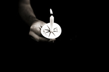 A hand holding a Christmas Eve candle