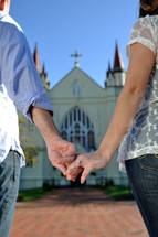 couple walking holding hands to a church 