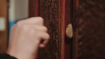 Close-up of hand knocking on door and opening of it