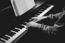 A man plays  chord on a piano