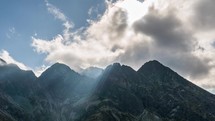 Dramatic clouds and sunbeam over alps mountains peak. Getting dark in sunny summer day Time-lapse
