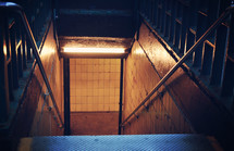 looking down a dark stairway in a subway 