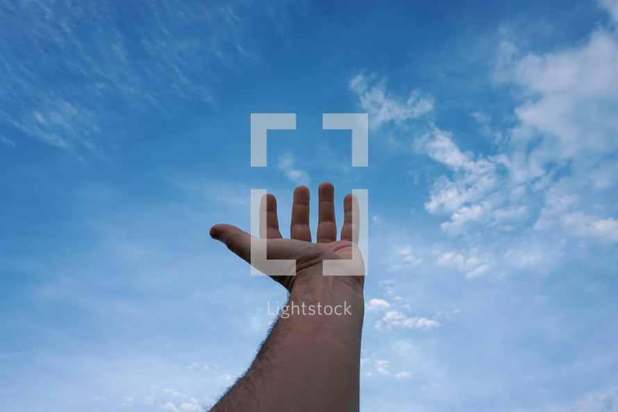 man hand gesturing and reaching the blue sky