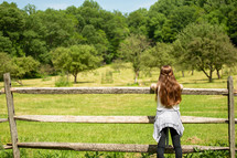 girl looking out into an orchard 