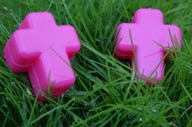 cross shaped Easter eggs in wet green grass for an Easter egg hunt