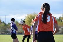 girls playing in a soccer game 