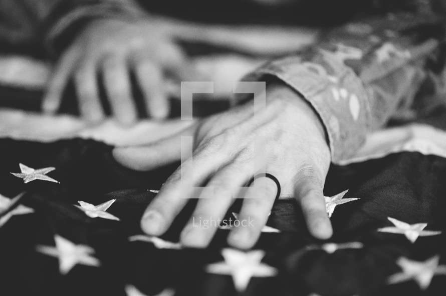 hands of a soldier on an American flag 