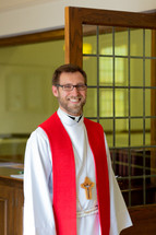 priest standing in the door of his church 
