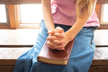 girl praying with a Bible in her lap