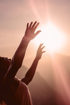 A woman raises her hands in worship
