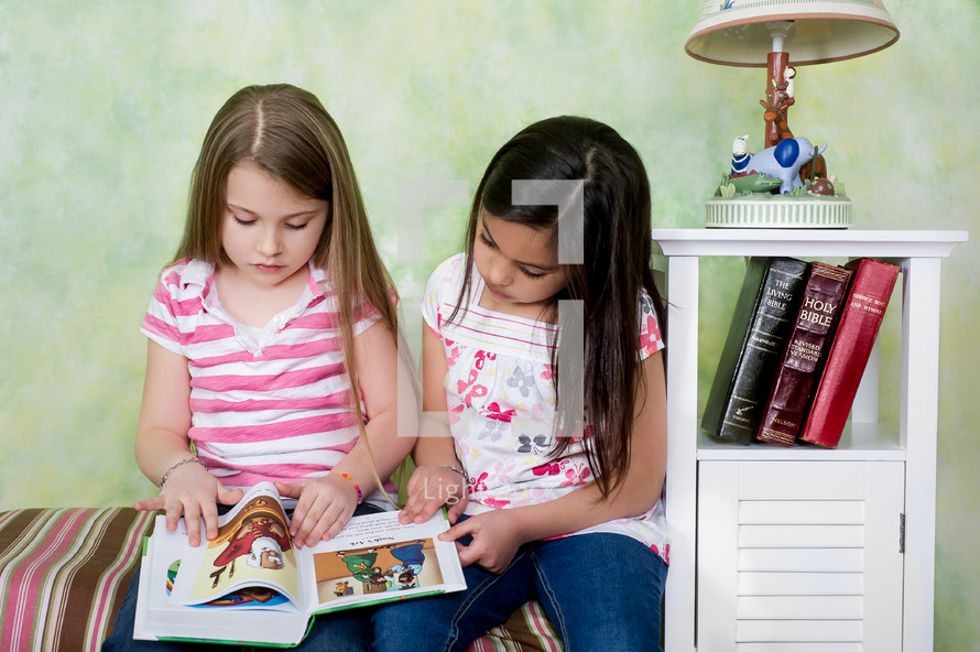 Two girls reading a Bible story.