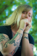 woman with tattooed praying 