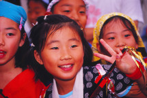a young girl showing a peace sign 