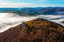 Aerial Drone Shot: Sightseeing Tower in Brezno, Autumn Scenery with Misty Morning and Cloud Inversion in Horehronie Region