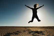 silhouette of a woman jumping in mid air 