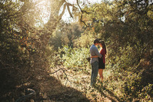 sunlight shining on a couple hugging outdoors under a tree 