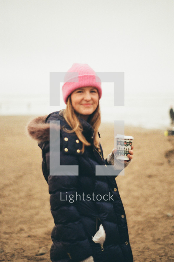 portrait of a woman in a beanie holding coffee 