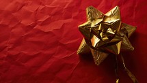 Golden bow on red paper background with copy space. Christmas concept.