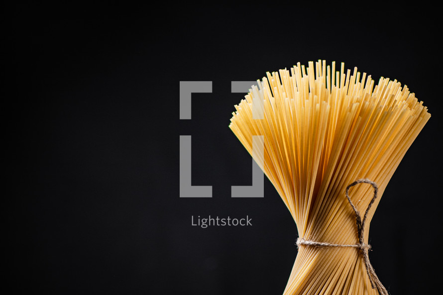 A pile of spaghetti dry on the table. Against a dark background. High quality photo