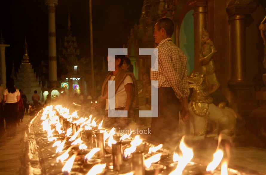 people lighting candles at a festival 