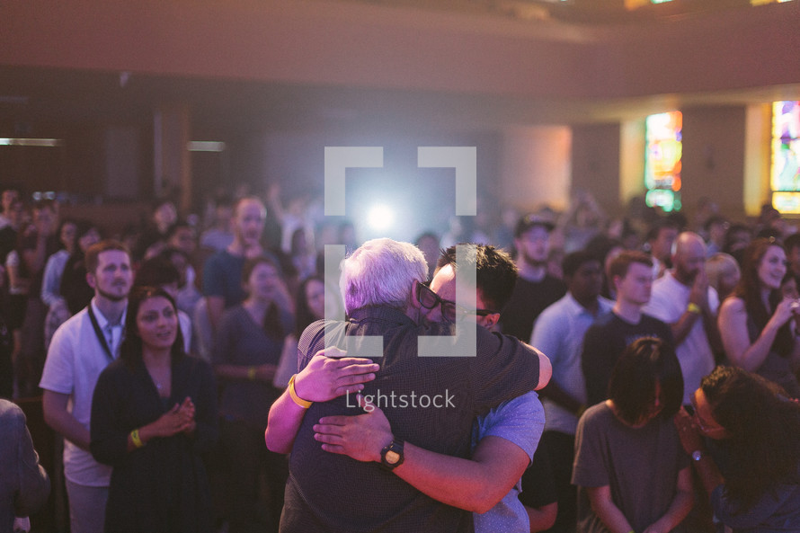 men hugging at a worship service 