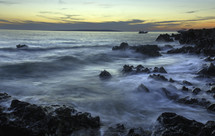 waves along a rocky shore at sunset 