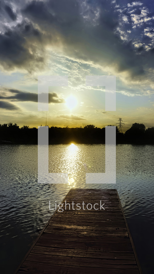 a dock at sunset over a lake 