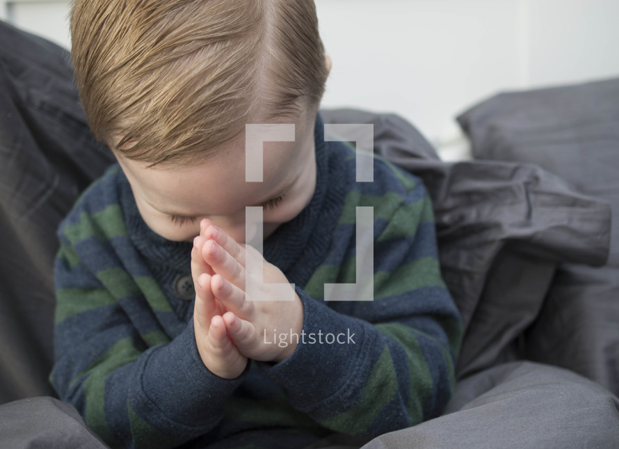 toddler boy with praying hands 
