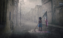 A little girl holds an American flag that is melting in the rain storm