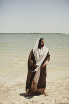 Jesus of Nazareth stands beside a lake.