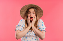 Woman afraid of something, she in shock on pink backdrop.Holding head, screaming. High quality photo