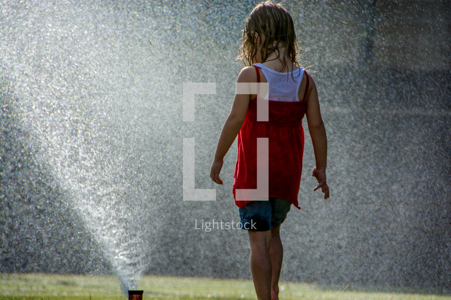 Child playing in the water sprinklers.